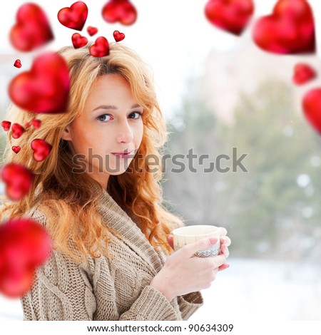 Portrait of beautiful red hair girl drinking coffee on winter background. Red hearts are flying around her. Valentine concept