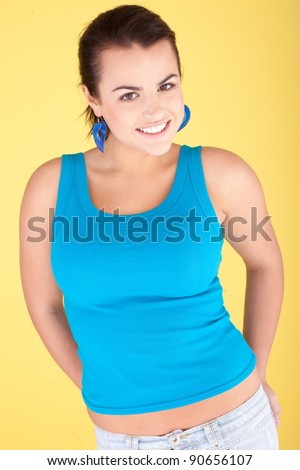 Mid long shot of a young brunette woman in a blue top.