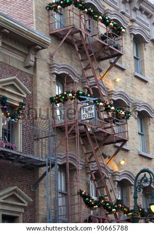 Room to let on steel fire escape stairs with Christmas garland and bulbs