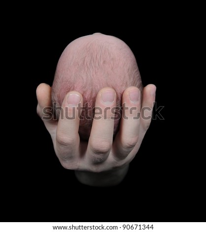 father's hand holding newborn head. isolated on black