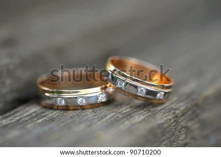 two golden wedding rings on wooden background