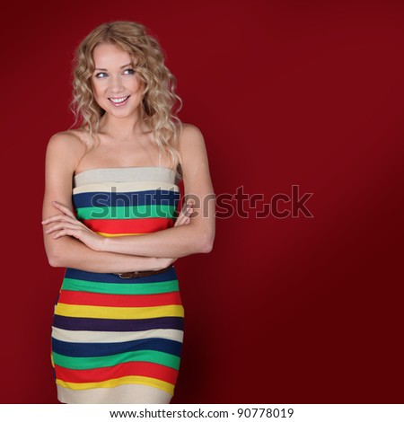 Charming blond woman with arms crossed on red background