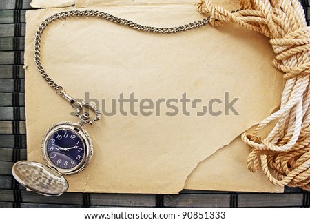 Marine themed frame of paper sheet, watches and sailor rope on a wooden mat.