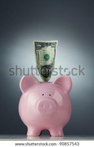 Piggy bank with one dollar bill