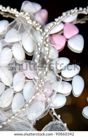close-up of wedding crowns and almond sweets cover with veil