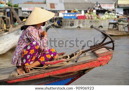 Vietnamese Woman on a Boat at a Morning Floating Market in the Mekong Delta.