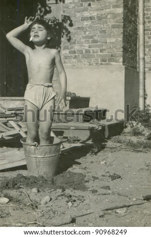Vintage photo of young girl bathing in a bucket(fifties)