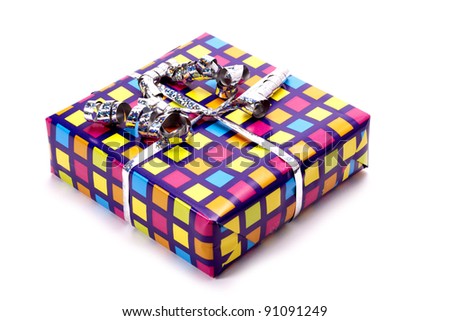 A present wrapped in colourful rapping paper on a white background. Colourful gift.