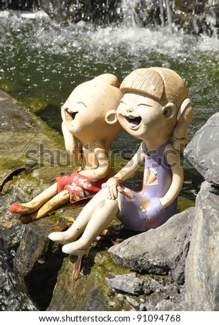 Clay doll sit near waterfall