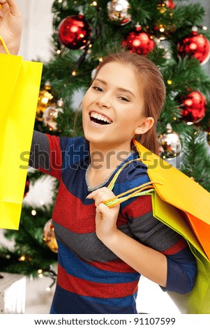 bright picture of happy woman with shopping bags and christmas tree