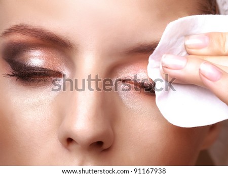Closeup portrait of a pretty young woman using cotton on closed eyes Royalty-Free Stock Photo #91167938