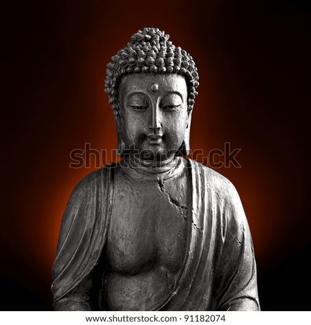Buddha statue against red and black background
