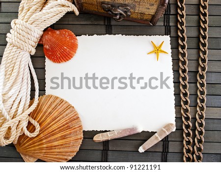 Marine theme frame of paper sheet, seashells, sailor rope, chain  and little chest on a wooden mat.