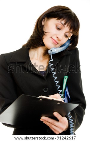 Female executive writing down notes while talking on phone