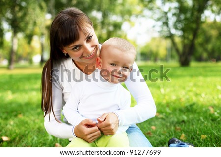 Young mother with her little son in summer park