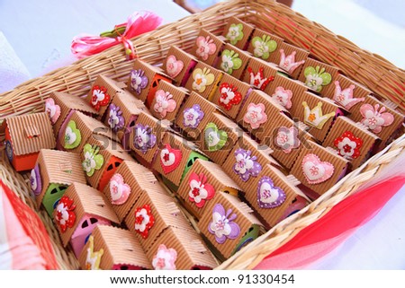 Basket with sweets packed on a small decorated paper houses