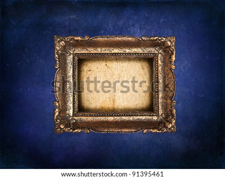 Empty golden frame on blue grunge wall