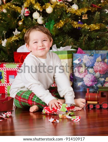 Young boy unwrapping presents on Christmas morning