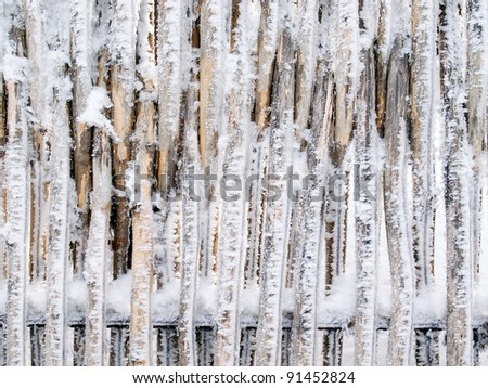 Snowbound fence closeup texture background.