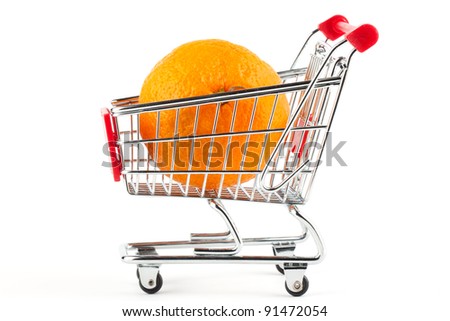 Buying healthy food. Shopping trolley with orange on white