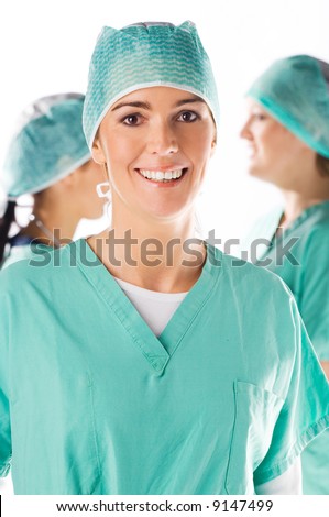 Beautiful young nurse smiling with her team in the background