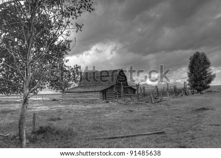 Storm clouds over Old Barn and stock pens in bad need of repair; deserted farm in Grand Teton National Park, Wyoming.  Image converted from color to black and white.