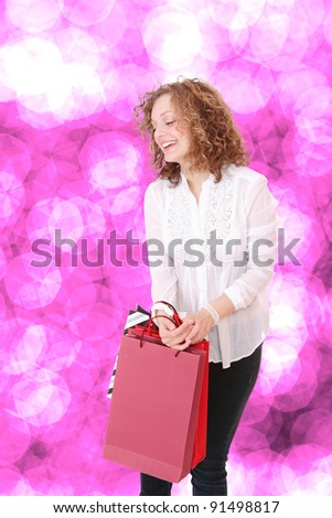 Portrait of an attractive young girl with shopping bags in front of nice pink bokeh background