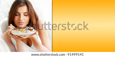 Young beautiful woman with a cake. Closeup portrait. Sitting on sofa at her home. Prepared copyspace at right side of the image