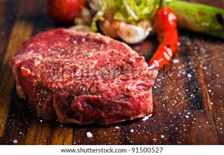 Juicy  beef steak with pepper on a butcher block Royalty-Free Stock Photo #91500527