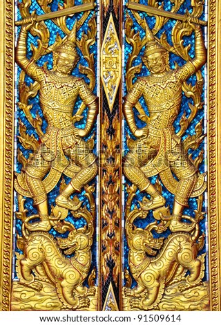 Siamese art texture carved on the temple door in shape of giant in buddhism believe.