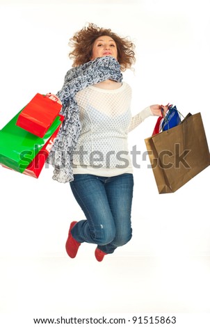 Cheerful redhead woman leaping with shopping bags isolated on white background
