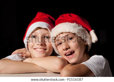 cute two boys in santa hats on dark