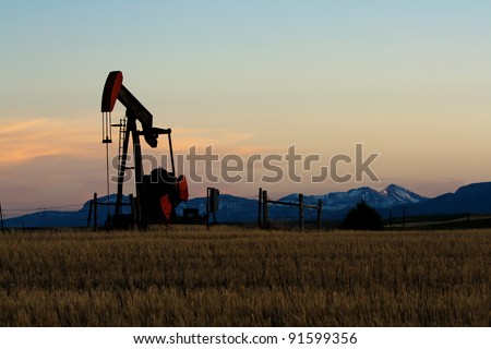 Oil and gas industry. Silhouette of oil pump against a sunset sky