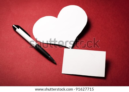 valentine's paper heart with a blank business card on a red background