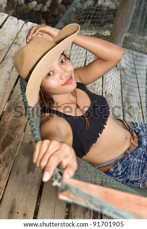 Young woman in cowboy hat resting on a hammock