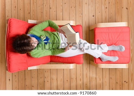 Middle aged woman is reading a book. Studio picture