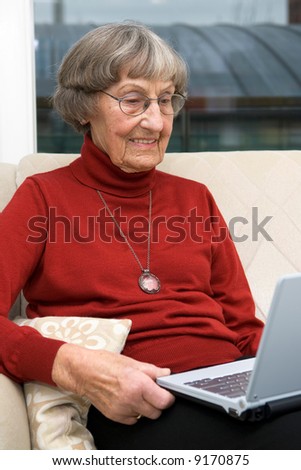 Activ senior woman (80s) with a modern and small notebook