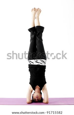 Portrait of a cute young asian female practicing yoga on a mat