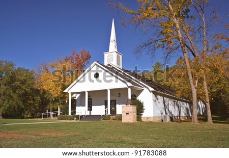 Small Church in Autumn Fall Leaves and Blue Sky