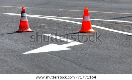 Road block with white arrow showing the alternate way