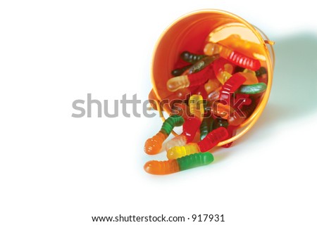 Gummy worms spill from a bright orange pail.
