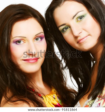 Two girl friends together smiling.Studio shot.