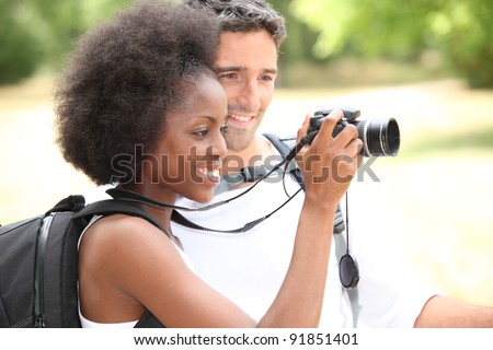 couple of tourists looking a camera