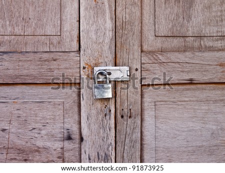 old wooden door locked by an old padlock