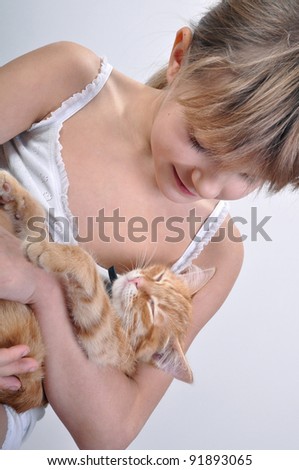 Trustful red kitten asleep in girls arms.