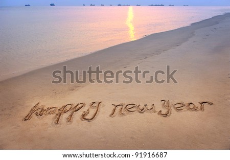 happy new year written in the sand