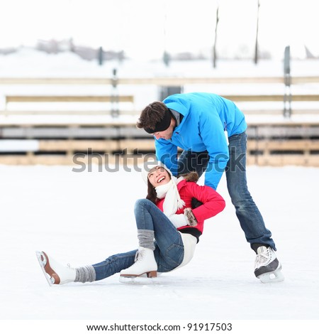Ice skating couple having winter fun on ice skates in Old Port, Montreal, Quebec, Canada.