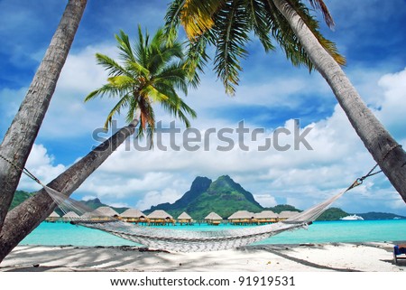 View of the Otemanu mountain , looking towards through the palms with hammock and the lagoon , Bora Bora , French Polynesia Royalty-Free Stock Photo #91919531