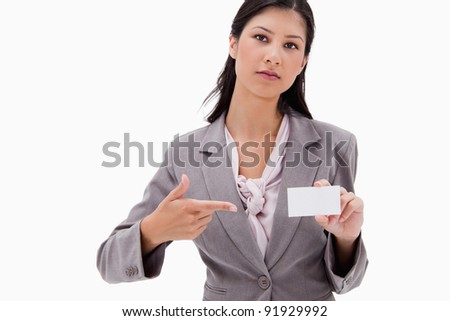 Businesswoman pointing at name badge against a white background