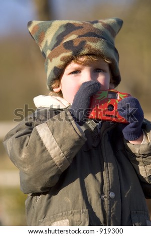 A young boy wrapped up against the cold taking pictures